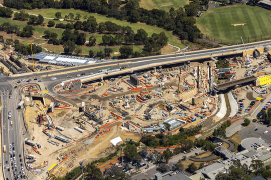 Aerial view of the construction site near the Eastern Freeway and green spaces, punctuated by the stark contrast of raw earth and steel against the backdrop of Bulleen, Victoria, Australia.