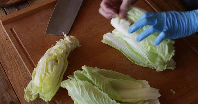 Chinese cabbage bai cai leaves lined up and cut with sharp angle shape using wide Asian style cleaver knife