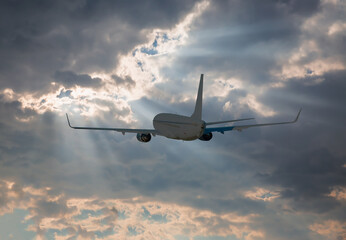 Obraz premium White passenger airplane flying in the sky amazing clouds in the background - Travel by air transport
