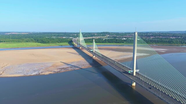 Liverpool, Merseyside, UK, June 19, 2025; Aerial 4K video footage of the Mersey Gateway toll bridge with stunning views over the River Mersey, Liverpool, UK.
