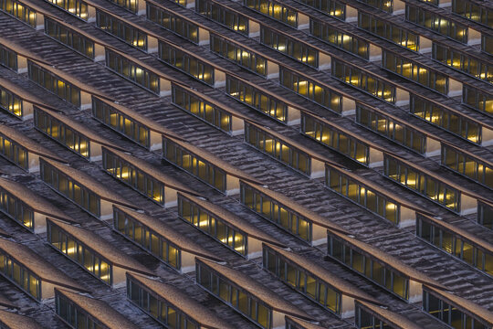 Aerial view of a modern architectural marvel with rows of illuminated windows creating a captivating geometric pattern, Roma, Lazio, Italy.