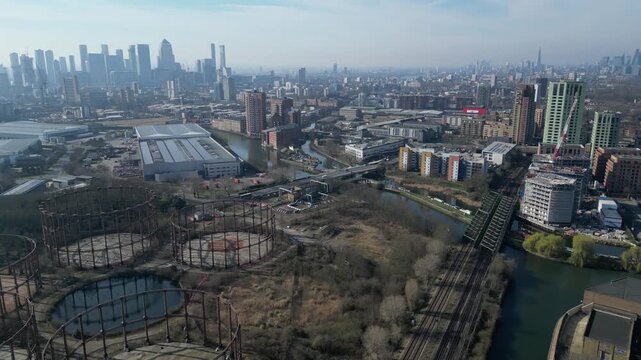 Historic Bromley-by-Bow Gas Works in East London: disused gasholder frames await urban redevelopment against the distant Canary Wharf skyline.