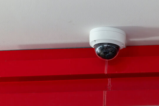 security home camera, CCTV 360 degree on white ceiling and red office wall.