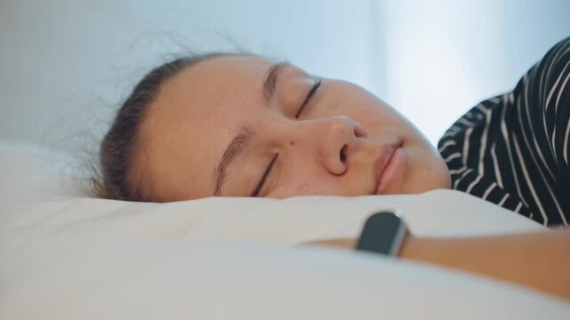 Resting after travel. Woman relaxes in peaceful hotel environment. Tired female guest decompresses in dimly lit hotel space. Asian woman takes restful pause on cozy hotel bed after busy day