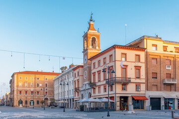 Historic buildings and clock tower in Piazza Tre Martiri, Rimini, Italy. The pedestrian square with...
