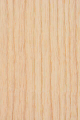 A flat top view of a light colored natural wood surface showing a smooth vertical grain pattern and fine organic details
