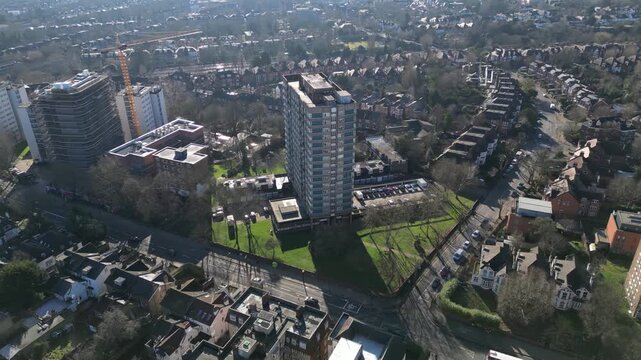 Construction workers renovate and clad Windmill Court tower blocks on Shoot Up Hill in Kilburn, London, to modernize the housing.