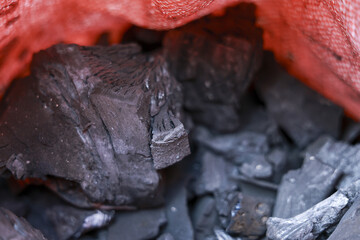 Close up background of natural black charcoal lump. This carbon coal fuel source has rough texture, ready for barbecue or industry, representing raw powerful material