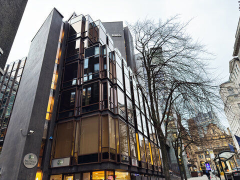 Modern glass Pall Mall Medical facade building in Manchester city centre with bare trees and urban mall
