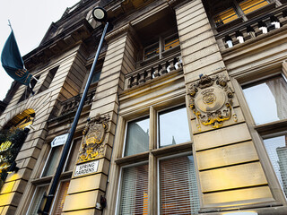 Naklejka premium Historic Manchester building facade with ornate crest and signs reading Spring Gardens and Post Office