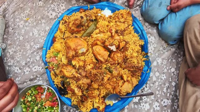 Jordan shared chicken rice platter with salad and yogurt communal dining hands eating traditional Middle East cuisine family gathering close up