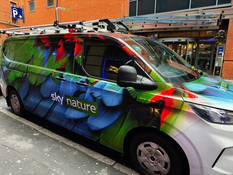 Colorful nature themed van wrap advertising Sky Nature television station in Manchester UK on a city street
