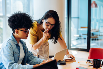 Reviewing the details: Teammates refining work at the laptop