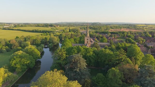 Drone ascend over the River Avon, starting from the town landscape and rising to reveal the magnificent spire of the Gothic Holy Trinity Church, Shakespeare&rsquo;s final resting place.