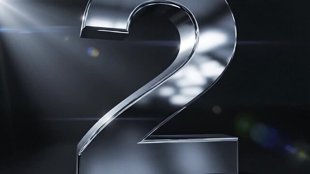 A shiny llic number two stands prominently on a dark reflective surface