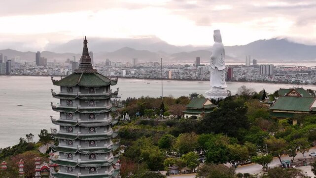 Aerial view of Linh ung pagoda with lady buddha statue overlooking the city of da nang, vietnam and the south china sea at sunset