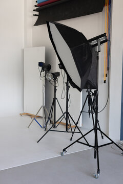 Equipment in a photo studio. Lighting stands with lamps on a white cyclorama background.