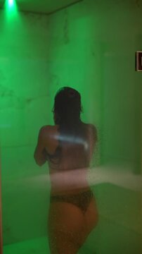 Contemplative woman in vibrant steam showers with reflective ambiance