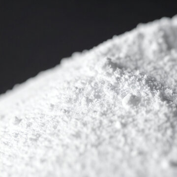 White titanium dioxide powder heap, blurred background. Calcium carbonate, magnesium or zinc oxide