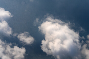 Fototapeta premium high angle view of clouds and sea during flight