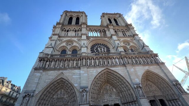 Front view of the Notre-Dame Cathedral west facade with its rose window architecture on a sunny day in Paris, France