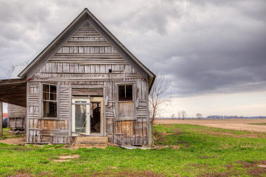 Abandoned Wooden House: An Echo of the Past. A weathered and worn abandoned wooden house in a rural landscape. 