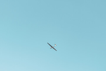Glider Soaring in Clear Blue Sky with Copy Space
