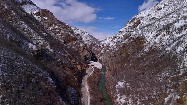 Winter Road Through a Snowy Mountain Canyon with Turquoise River