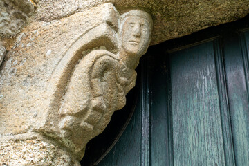 Expressive 12th-century Romanesque carved corbel on the portal of San Martiño de Agudelo church featuring a human figure, Barro, Pontevedra, Spain © Nandi Estévez