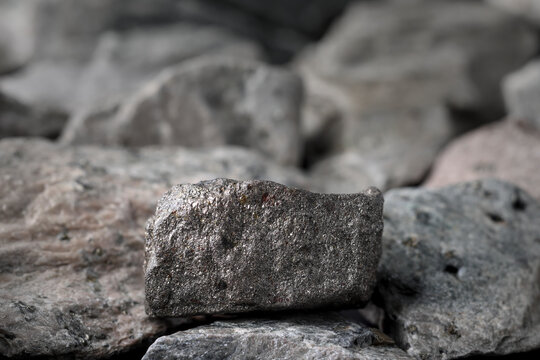 Nickel  (Ni) sulfide ore. Textured rock background. Mining critical strategic mineral, raw material. Stainless steel, alloy, lithium-ion battery cathode, catalyst, electroplating, coin uses