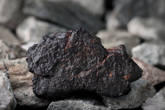 Manganese (Mn) ore. Textured rock background. Mining critical strategic mineral, raw material. Lithium-ion battery, steel, alloy uses