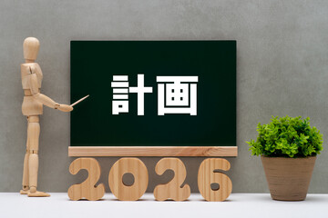 黒板に計画の文字と2026年の切り抜き文字とデッサン人形