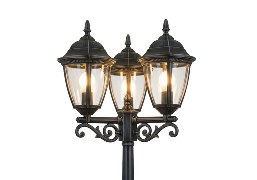 Classic black three-headed street lamp with illuminated bulbs and ornate details, providing outdoor lighting for pathways.