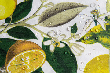 A beautiful and bright square tablecloth featuring a vibrant Mediterranean print of yellow lemons, green leaves, white blossoms, birds, and butterflies.  © Oleksandra Dyka
