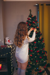 young pretty woman decorating a Christmas tree