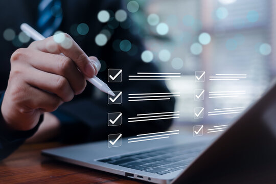 Business professional completing online checklist on digital interface using stylus and laptop, task management, quality assurance, project planning, compliance audit and workflow optimization concept