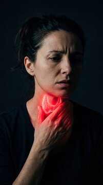 Woman with red glowing thyroid gland on neck holding her throat. Concept of thyroid disease, pain, illness, hormonal problem