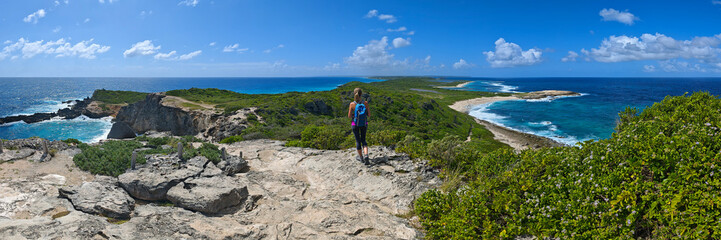 Young women is hiking at Pointe des Chateaux - Caribbean island Guadeloupe (Panoramic view)
