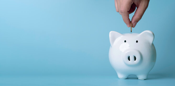 Hand putting coin into piggy bank, savings and investment concept for personal finance planning, budgeting strategy, wealth growth and financial security to get more dividend and profit.