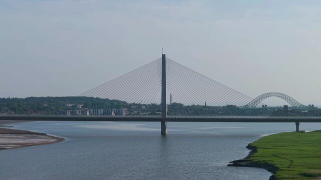 Liverpool, Merseyside, UK, June 19, 2025; Aerial 4K video footage of the Mersey Gateway toll bridge with stunning views over the River Mersey, Liverpool, UK.