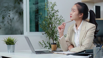 Thoughtful businesswoman pondering ideas in office