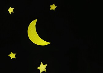Paper crescent moon and stars on black background