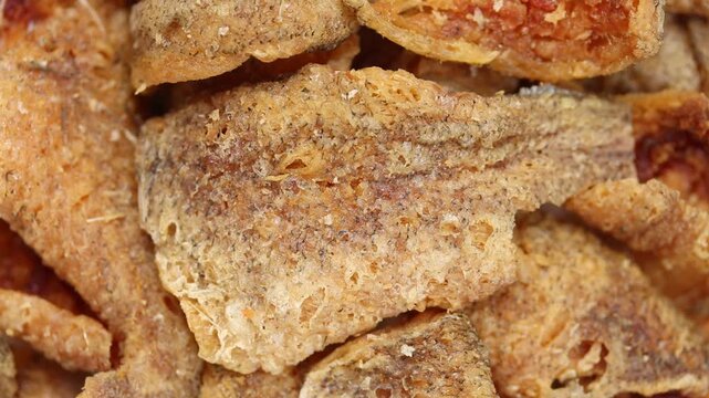 Pile of crispy fried boneless gourami fish fillets pieces rotating slowly. Thai food
