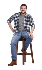 Fototapeta premium Smiling long-haul truck driver in checkered shirt sitting on stool against white background