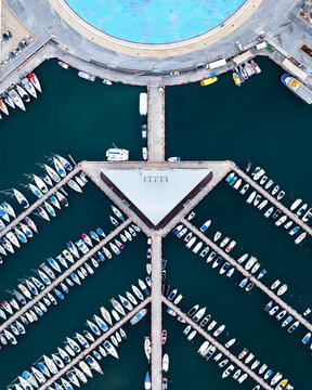 Aerial view of boats nestled in the marina's embrace, a symphony of masts against deep blue waters, a vibrant coastal mosaic, Ashdod, South District, Israel.