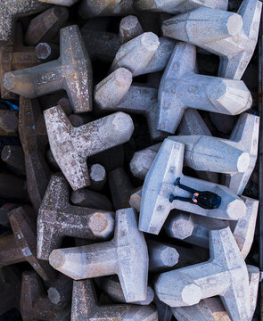 Aerial view of grey dolosse concrete blocks, their angular forms creating a textured landscape against the backdrop of the coast, Ashdod, South District, Israel.