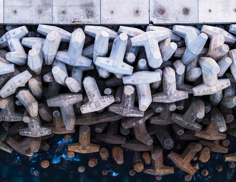 Aerial view of concrete tetrapods forming a robust seawall, their geometric shapes stark against the dark water, Ashdod, South District, Israel.