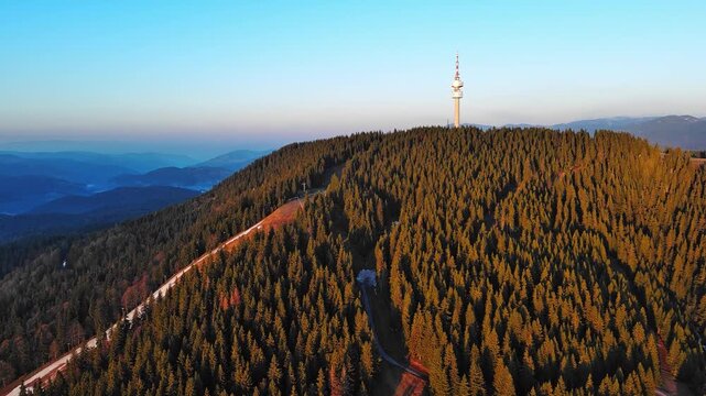 Tower Snezhana on peak of Snezhana covered with spruce forests in Rhodope mountains