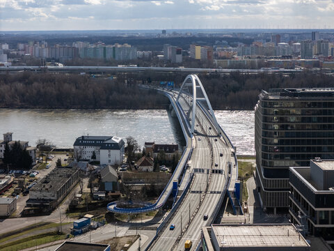 Aerial view of the Apollo bridge arcing gracefully over the tranquil waters of the river, connecting the modern cityscape with lush greenery, Bratislava, Bratislavsky kraj, Slovakia.