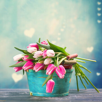 pink and white tulips in a blue rustic basket